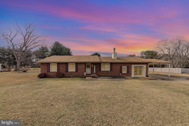 single story home featuring a carport and a yard