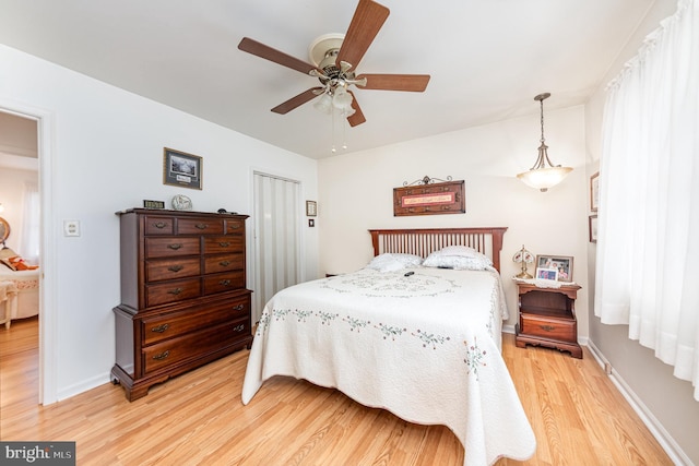 bedroom with ceiling fan, light hardwood / wood-style floors, and a closet