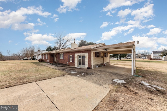 view of front of house with a carport and a front yard