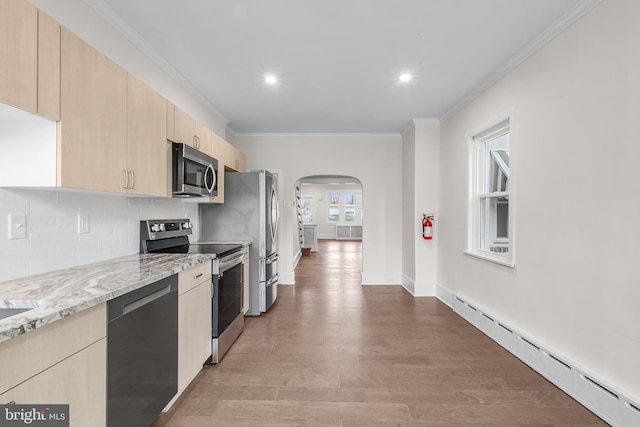 kitchen with light brown cabinetry, crown molding, baseboard heating, appliances with stainless steel finishes, and backsplash