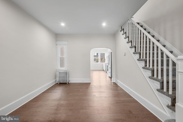 hall featuring radiator heating unit and dark hardwood / wood-style floors