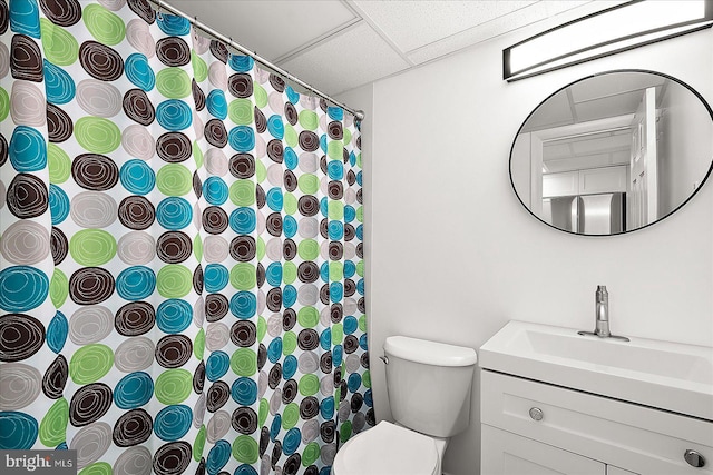 bathroom featuring vanity, a paneled ceiling, and toilet