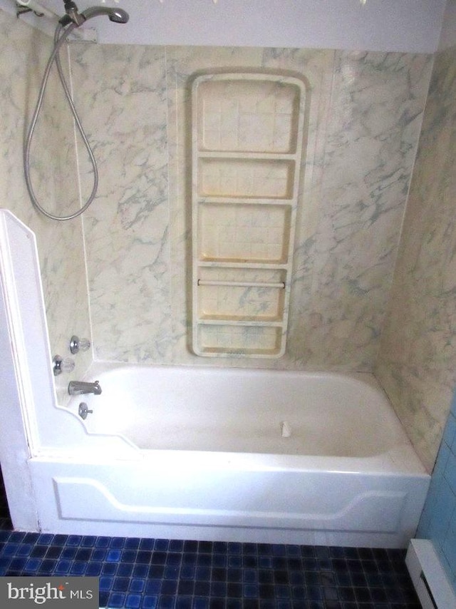 bathroom with tiled shower / bath and a baseboard heating unit