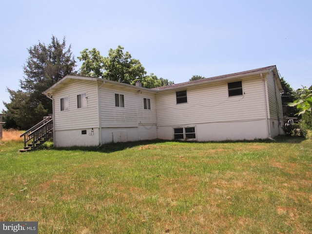 rear view of property with a lawn