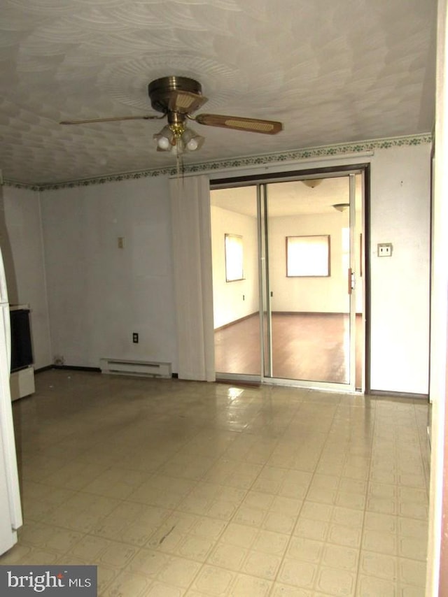 empty room with a baseboard heating unit and ceiling fan