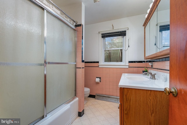 full bathroom with toilet, vanity, shower / bath combination with glass door, and tile walls