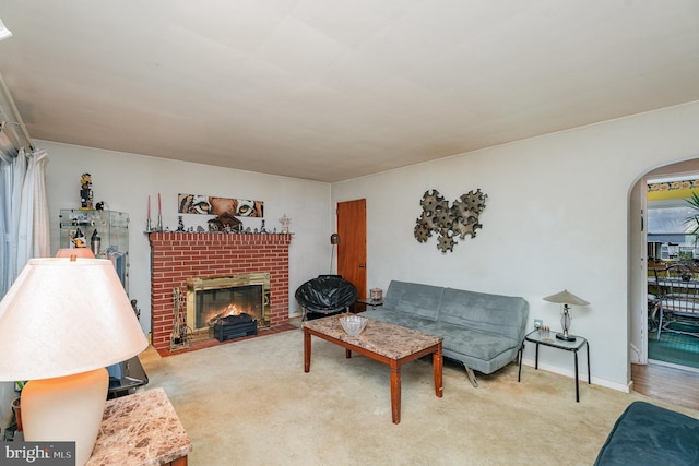 living room with a brick fireplace and carpet