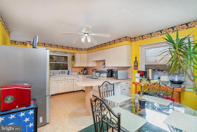 kitchen with ceiling fan, stainless steel appliances, decorative backsplash, and white cabinets