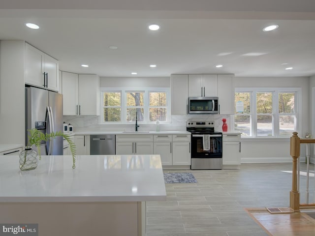 kitchen with white cabinetry, sink, and stainless steel appliances