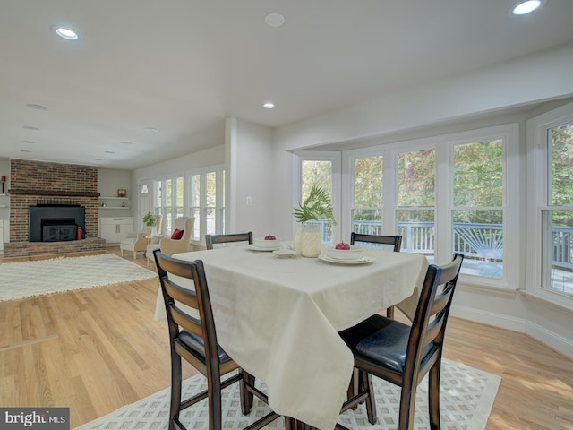 dining room with a fireplace and light wood-type flooring