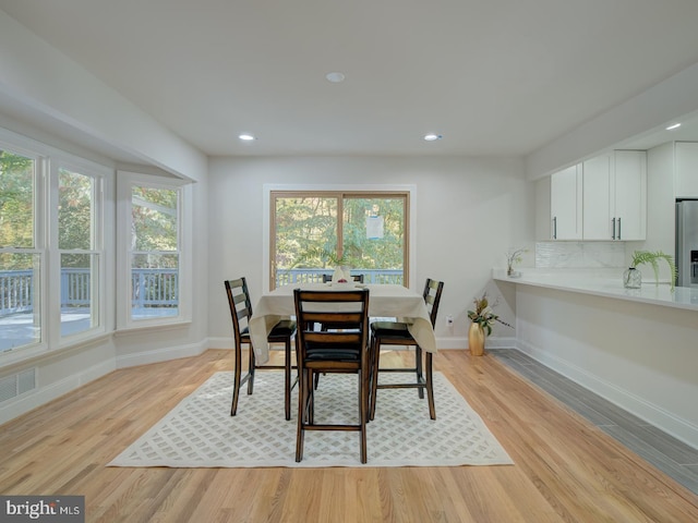 dining area with a wealth of natural light and light wood-type flooring