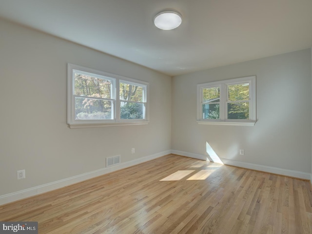 spare room with a healthy amount of sunlight and light hardwood / wood-style floors