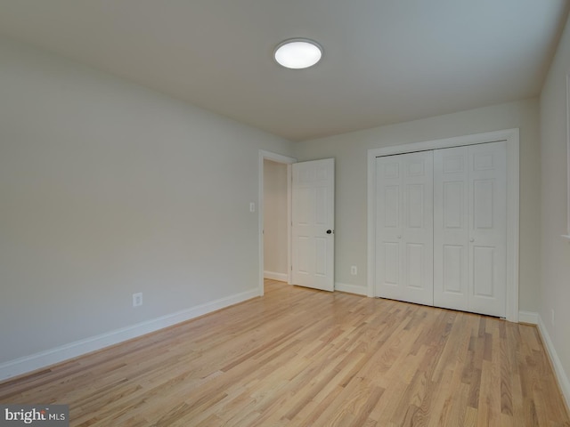 unfurnished bedroom with a closet and light hardwood / wood-style flooring