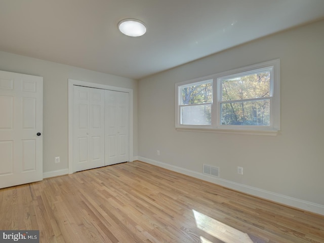 unfurnished bedroom featuring a closet and light wood-type flooring