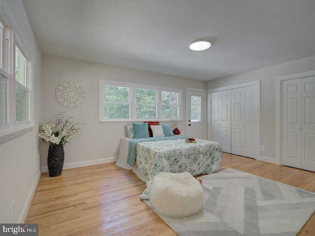 bedroom featuring two closets and light wood-type flooring