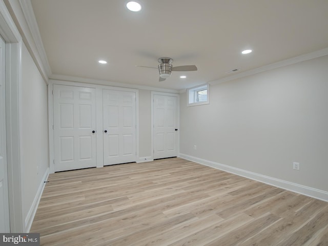 unfurnished bedroom with ornamental molding, two closets, ceiling fan, and light wood-type flooring