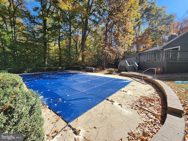 view of swimming pool with a wooden deck and a patio