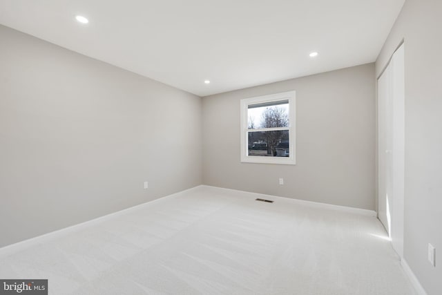 unfurnished room featuring light carpet