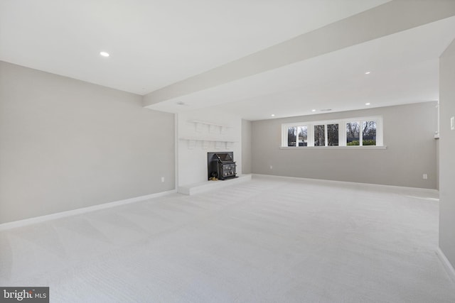 unfurnished living room with light carpet and a wood stove