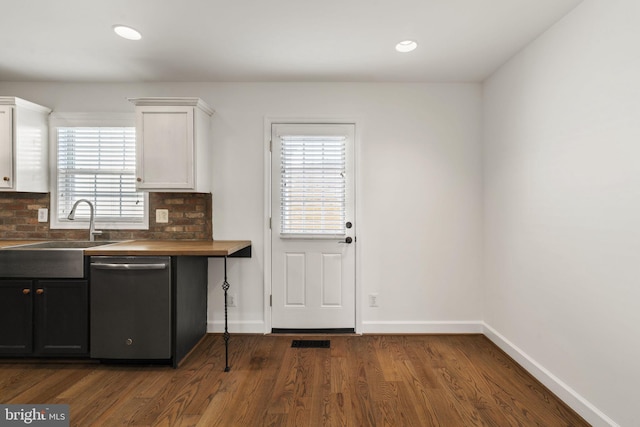 kitchen featuring sink, wooden counters, dark hardwood / wood-style floors, dishwasher, and white cabinets