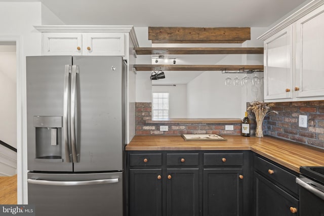 kitchen featuring range with electric cooktop, wood counters, white cabinetry, stainless steel fridge with ice dispenser, and beam ceiling