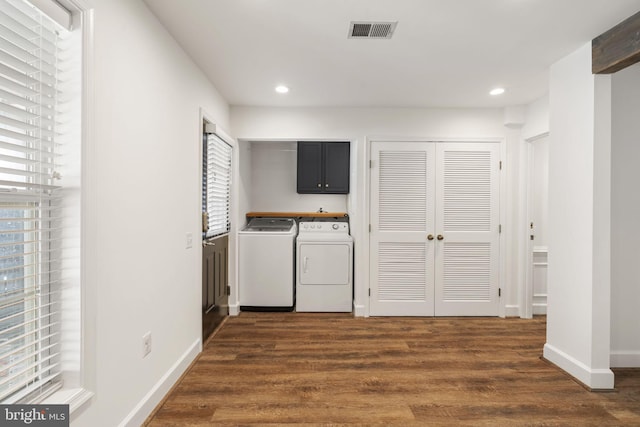 washroom featuring cabinets, dark hardwood / wood-style floors, and washing machine and clothes dryer