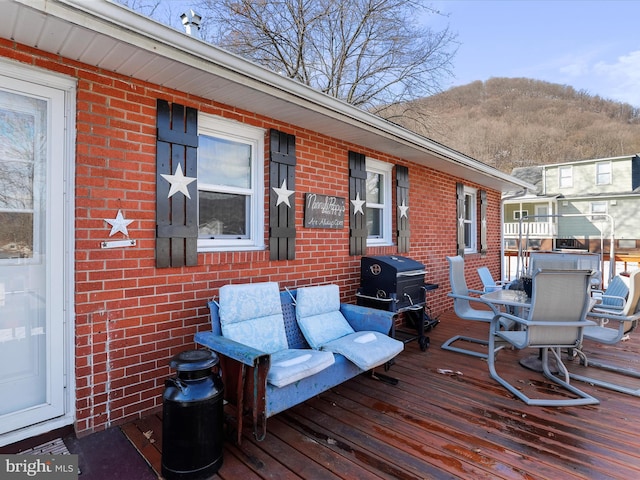 wooden terrace featuring a mountain view and a grill