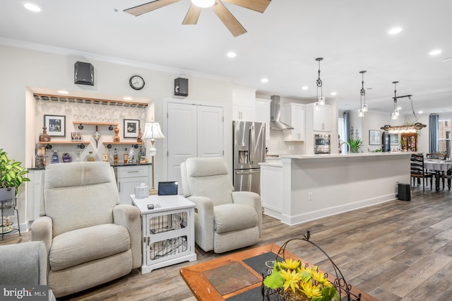 living room featuring ornamental molding, recessed lighting, light wood-style flooring, and a ceiling fan