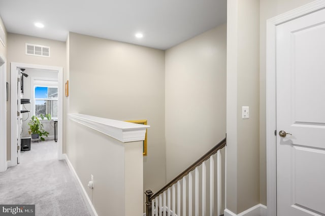 hall featuring recessed lighting, carpet flooring, visible vents, an upstairs landing, and baseboards