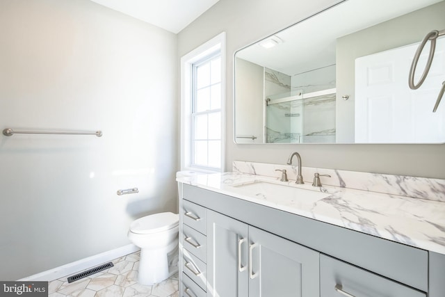 bathroom featuring vanity, toilet, and an enclosed shower