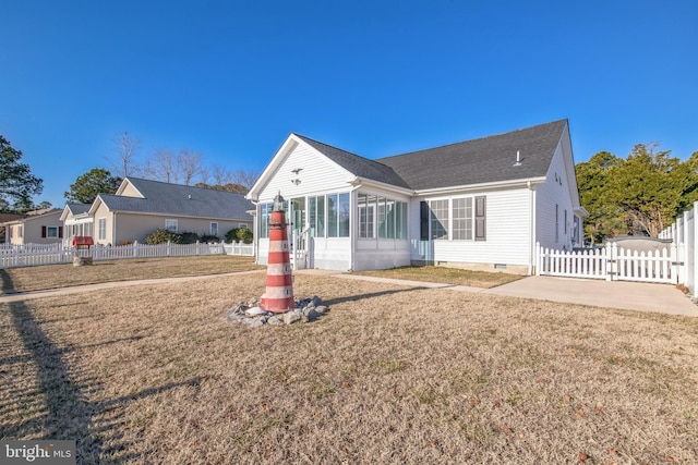 exterior space featuring a sunroom and a front lawn