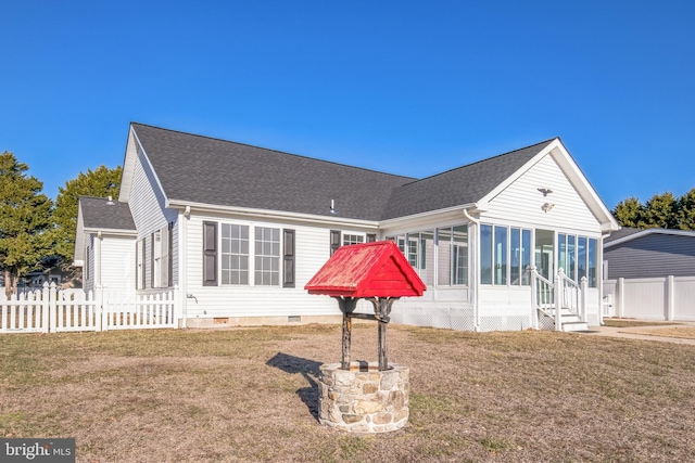 back of property with a yard and a sunroom