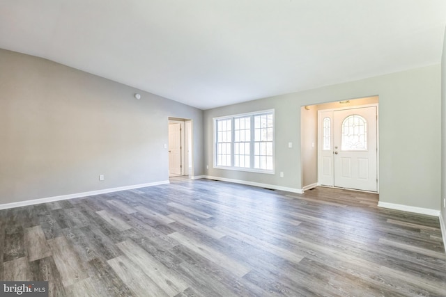 entrance foyer with vaulted ceiling and dark hardwood / wood-style floors