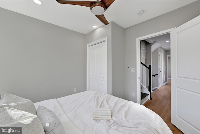 bedroom with hardwood / wood-style flooring, ceiling fan, and a closet