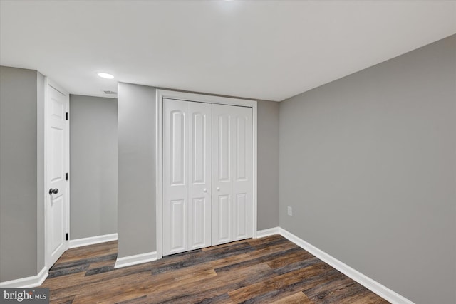 unfurnished bedroom featuring dark hardwood / wood-style floors and a closet