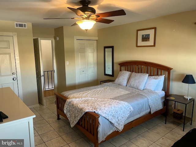 bedroom featuring light tile patterned flooring, ceiling fan, and a closet