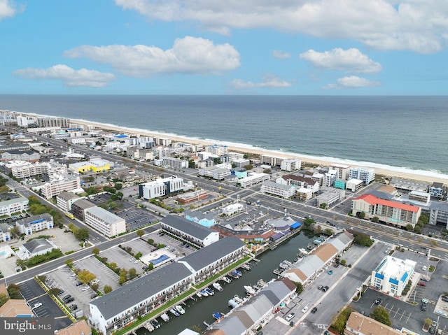 birds eye view of property with a water view and a beach view