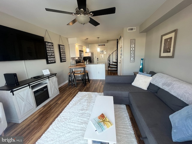 living room with ceiling fan and dark hardwood / wood-style floors