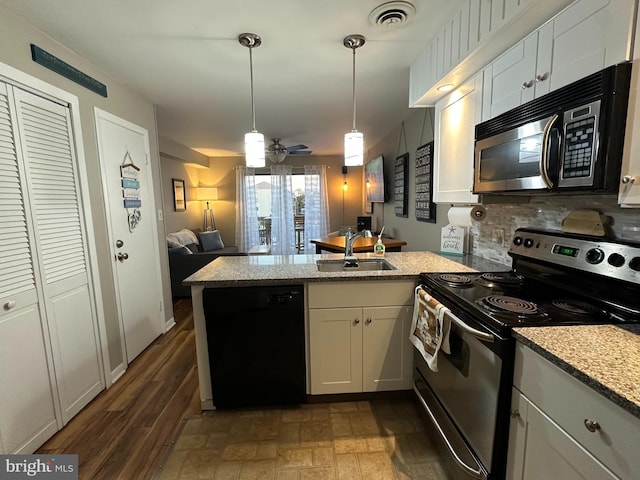 kitchen with appliances with stainless steel finishes, white cabinetry, sink, hanging light fixtures, and light stone counters