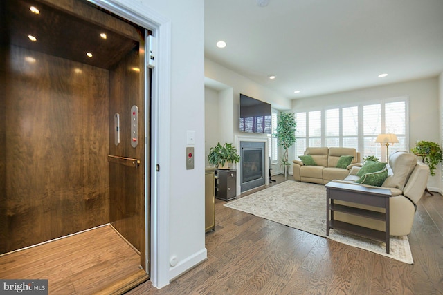 living room with elevator and hardwood / wood-style floors