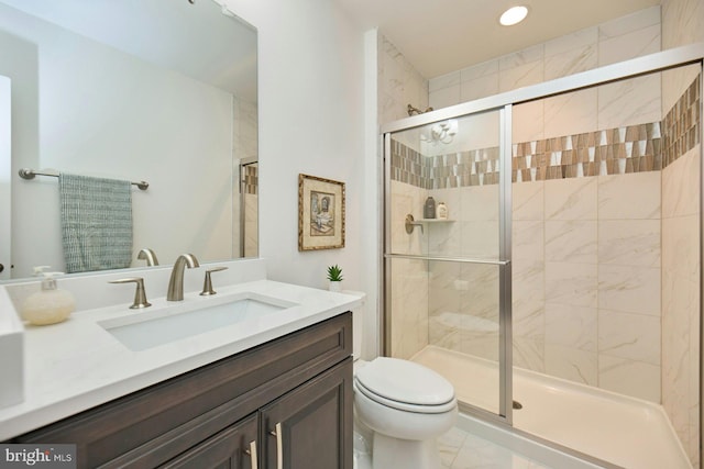 bathroom with vanity, toilet, and a shower with shower door