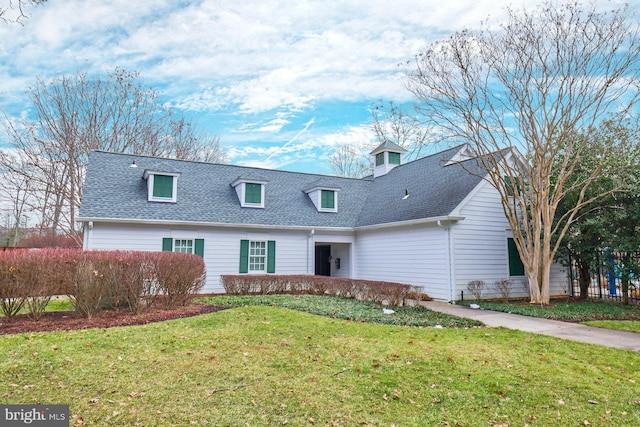 cape cod home with a front lawn