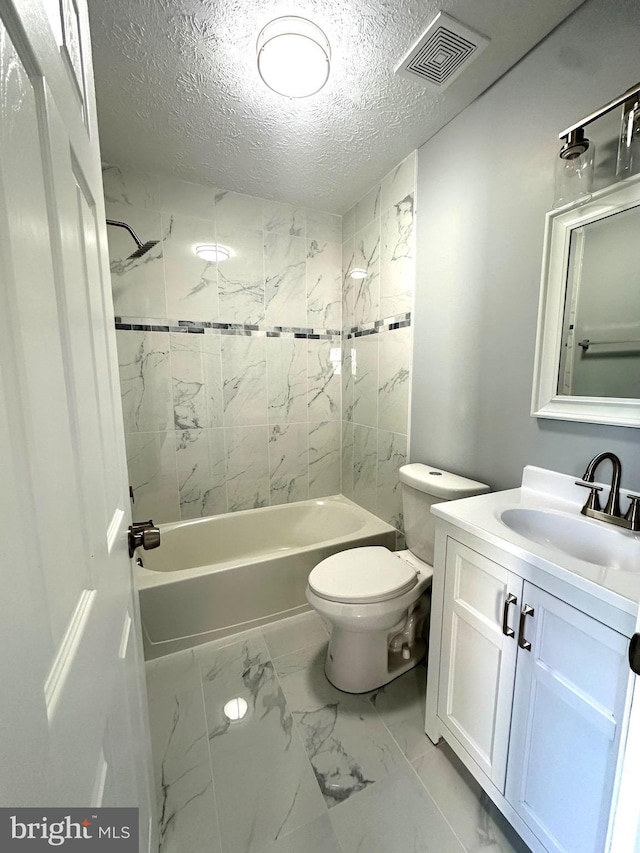 full bathroom featuring vanity, toilet, tiled shower / bath combo, and a textured ceiling