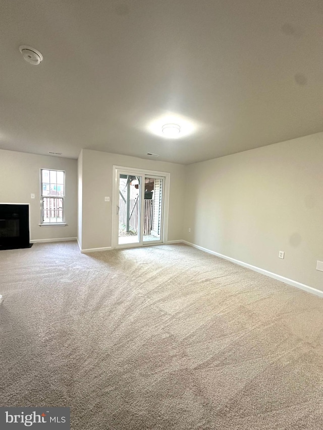 unfurnished living room with light colored carpet