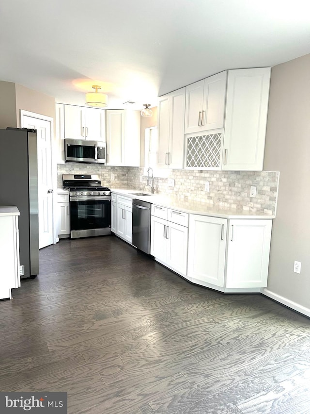 kitchen featuring tasteful backsplash, sink, white cabinets, and appliances with stainless steel finishes