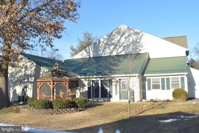 rear view of property featuring a gazebo and metal roof