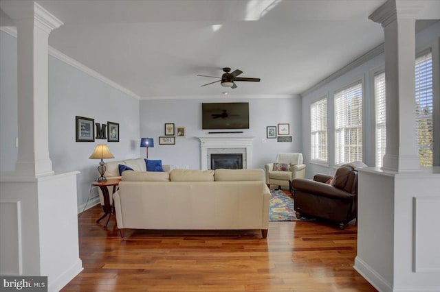 living room featuring crown molding, ceiling fan, decorative columns, and hardwood / wood-style flooring