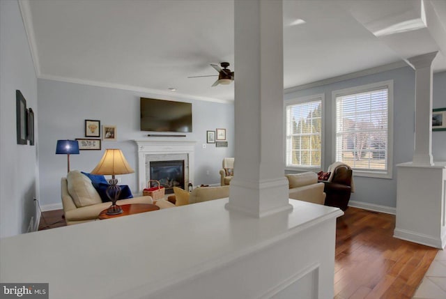 living room featuring ceiling fan, ornamental molding, hardwood / wood-style floors, and ornate columns