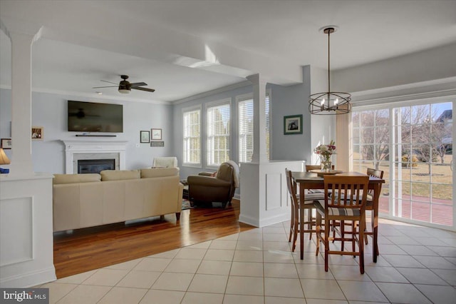 dining room with light tile patterned flooring, ornamental molding, and decorative columns