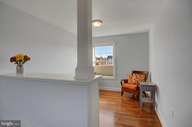 living area with hardwood / wood-style floors and ornate columns